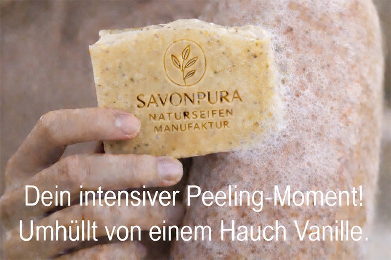 Mohn-Peeling Seife wird in der Hand an Arm gehalten mit Schaum. Mit Text "Dein intensiver Peeling-Moment."