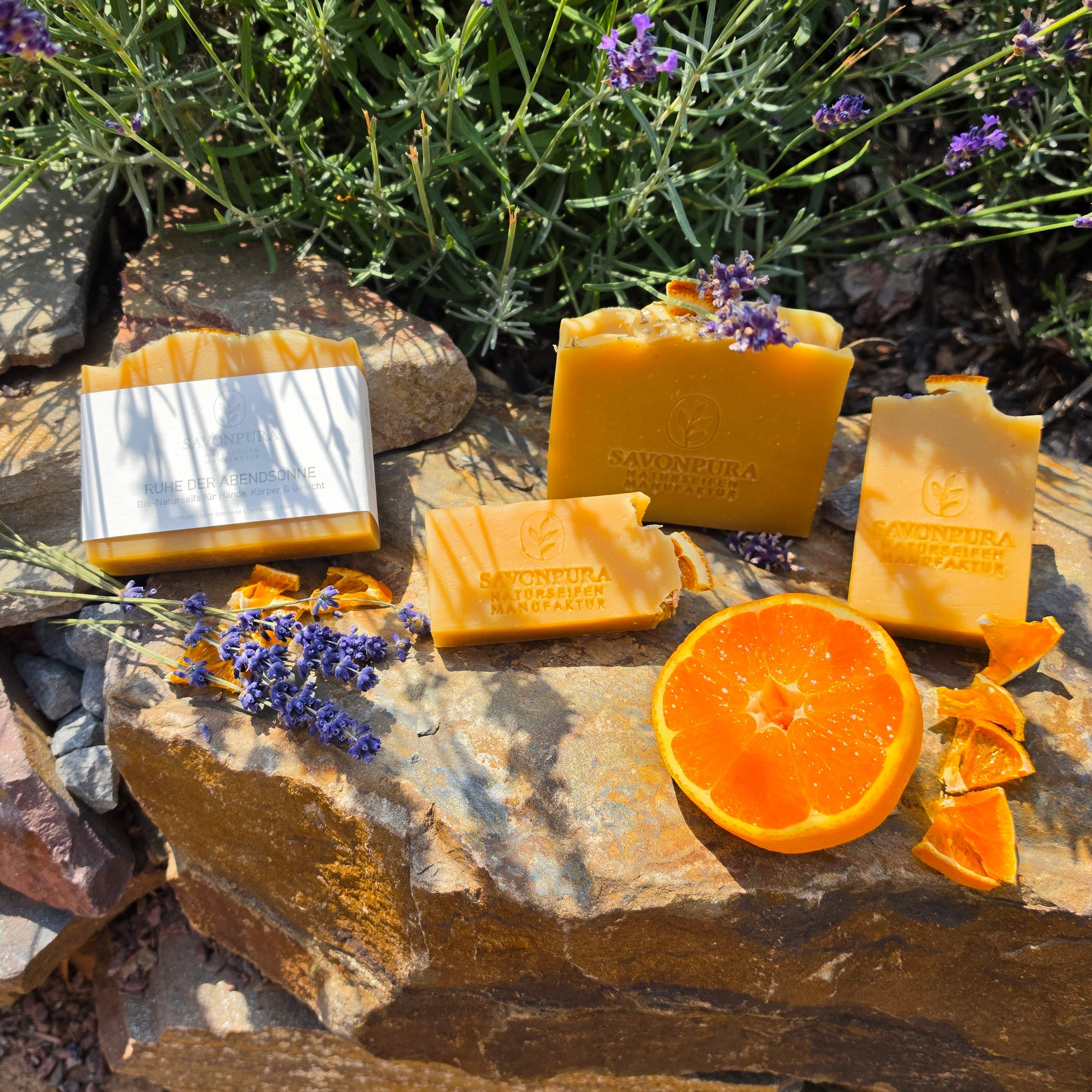 4 orangene Seifen auf Naturstein mit Lavendel und Orangen