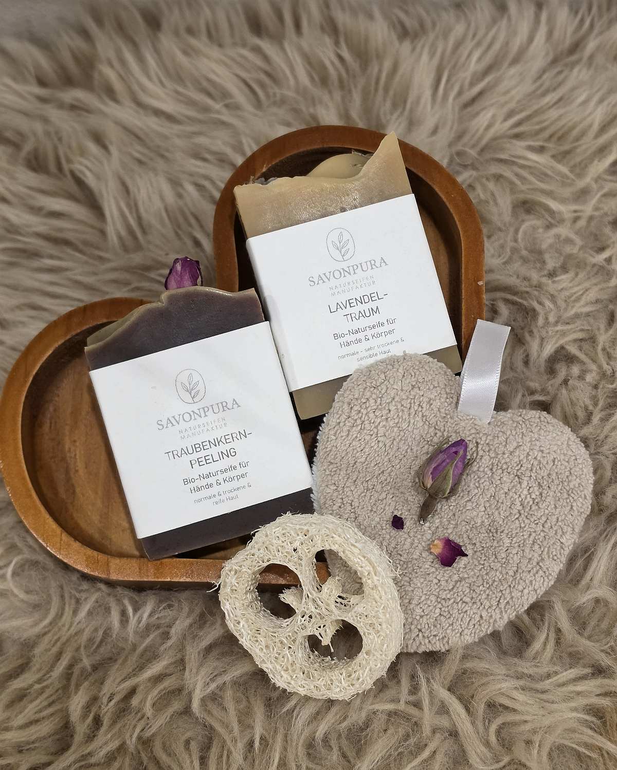 2 Seifen Lavendel-Traum und Traubenkern-Peeling jeweils 60g auf Fell und Holz-Herz liegend mit Naturdeko.