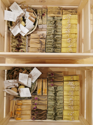 Körbe mit Seifen in verschiedenen Farben und Formen, ordentlich angeordnet in Holzkisten.