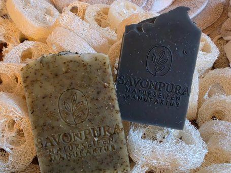 Hafermilch-Schwarzkümmel Seifenset Zwei Seifen in hübschen Verpackungen auf einem herzförmigen Holztablett.